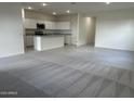 Bright open-concept space blending the living room and kitchen with modern gray tiling and carpet floors at 2076 E Bucking Bronco Dr, San Tan Valley, AZ 85140