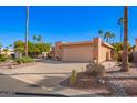 Side angle of the two car garage with light peach paint, a driveway, and desert landscaping in front of it at 26401 S Brentwood Dr, Sun Lakes, AZ 85248