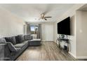 Cozy living area with stylish gray sofa, wood-look flooring, and bright natural light from the window at 2812 W Heatherbrae Dr, Phoenix, AZ 85017