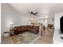 Cozy living room features a brown sectional couch and views into the kitchen, dining, and outdoor patio areas at 3031 S Los Altos --, Mesa, AZ 85202