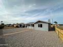 Single story home with gravel yard and a light-colored fence at 318 E Hill Dr, Avondale, AZ 85323