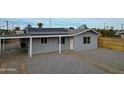 Single story home with gravel yard and a light-colored fence at 318 E Hill Dr, Avondale, AZ 85323