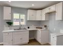 Bright kitchen featuring white cabinets, modern countertops, and stainless steel sink at 318 E Hill Dr, Avondale, AZ 85323