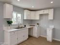 Bright kitchen featuring white cabinets, modern countertops, and stainless steel sink at 318 E Hill Dr, Avondale, AZ 85323