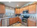 Well-lit kitchen featuring stainless steel appliances, tile backsplash, and warm wood cabinets with dark countertops at 34734 N Happy Jack Dr, San Tan Valley, AZ 85144