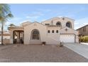 Beige stucco home with arched windows, gated courtyard entry at 3557 S Halsted Ct, Chandler, AZ 85286