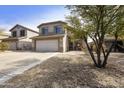 Two-story home with two car garage, desert landscape with a tall tree at 4439 E Coyote Wash Dr, Cave Creek, AZ 85331