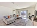 Bright living room with a sectional sofa, patterned rug, and sliding glass doors to the backyard at 454 N 19Th Pl, Coolidge, AZ 85128