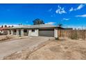 Inviting single-story home with attached garage, xeriscaped yard, and a vibrant turquoise-colored front door at 5902 W Wolf St, Phoenix, AZ 85033