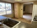 Spacious kitchen featuring abundant natural light and wood flooring leading into an open-concept living area at 723 E Garnet Ave, Mesa, AZ 85204