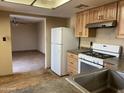 Functional kitchen with modern appliances, wood cabinets, and an open layout flowing into the living area at 723 E Garnet Ave, Mesa, AZ 85204