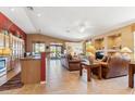 Open-concept living room featuring tile floors, vaulted ceilings, and views to the outside patio, dining area, and kitchen at 8212 E Masters Rd, Gold Canyon, AZ 85118