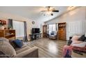 Bright living room featuring vaulted ceilings, a ceiling fan, hardwood floors, and lots of natural light at 12766 W Dreyfus Dr, El Mirage, AZ 85335