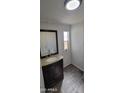 Bathroom showcasing a vanity with granite countertops and a decorative mirror at 1402 S 76Th Pl, Mesa, AZ 85209