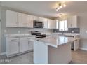 Modern kitchen boasts white cabinets, island, and stainless steel appliances at 15032 N 24Th N Pl, Phoenix, AZ 85032