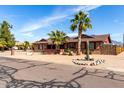 Desert home with mature palm trees, desert plants, and rock accents, offering a unique curb appeal at 2031 S Cactus Rd, Apache Junction, AZ 85119