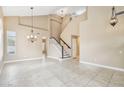 Bright living room with high ceilings, tile flooring, and staircase at 21960 N 70Th Dr, Glendale, AZ 85310