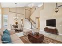 Bright living room with high ceilings, tile flooring, and staircase at 21960 N 70Th Dr, Glendale, AZ 85310