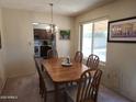 Bright dining room with a wood table and chairs adjacent to a window and a view into the kitchen at 2839 W Villa Maria Dr, Phoenix, AZ 85053