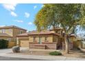 Lovely home with a two-car garage, desert landscaping, and a beautiful shade tree in the front yard at 4284 N 154Th Ave, Goodyear, AZ 85395