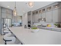 Modern kitchen featuring grey cabinets, stainless steel appliances, a large island and stylish pendant lighting at 4330 S Neutron --, Mesa, AZ 85212