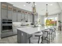 Modern kitchen features gray cabinets, a large island with seating, and pendant lighting at 4330 S Neutron --, Mesa, AZ 85212