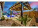 Outdoor pergola with a built-in grill, lounge chairs, and manicured landscaping at 4330 S Neutron --, Mesa, AZ 85212