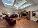 Spacious living room featuring vaulted ceilings with skylights, wood floors, and an entertainment center at 437 E Germann Rd # 152, San Tan Valley, AZ 85140