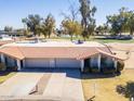 Aerial view of home showcasing tile roof, attached garages, driveway, and landscaping, backing onto a golf course at 4843 E Ajo Cir, Phoenix, AZ 85044