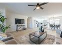 Spacious living room showcasing an open floor plan with a modern ceiling fan and updated decor at 4932 W Golden Ln, Glendale, AZ 85302