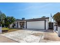 Single-story home with xeriscaped front yard, decorative concrete driveway, and attached two-car garage at 5223 W Lewis Ave, Phoenix, AZ 85035