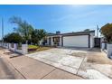 Single-story home featuring a two-car garage, xeriscaped yard, and decorative concrete driveway at 5223 W Lewis Ave, Phoenix, AZ 85035