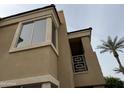 Exterior angle view of the home showcasing a balcony, palm tree, and light tan stucco finish at 7887 N 16Th St # 227, Phoenix, AZ 85020