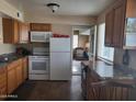 Well-lit kitchen featuring white appliances, wood cabinets, and tiled floors at 8211 E Garfield St # J206, Scottsdale, AZ 85257