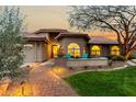 Charming single-story home with a red-tile roof, inviting front patio, and lush desert landscaping at 10105 E Larkspur Dr, Scottsdale, AZ 85260