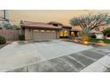 Spacious home with a large driveway, tile roof, and a beautifully landscaped front yard with green grass at 10105 E Larkspur Dr, Scottsdale, AZ 85260