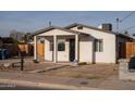 View of single story home with a covered porch, black front door and concrete walkway at 200 S 4Th St, Avondale, AZ 85323