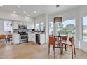 Bright kitchen with stainless steel appliances, white cabinets, and adjacent eat-in area at 2158 W Peninsula Cir, Chandler, AZ 85248