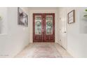Warm foyer with stylish double doors, neutral tile flooring, and elegant decor at 21842 E Via De Olivos --, Queen Creek, AZ 85142