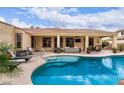 Backyard pool and spa featuring a covered patio with comfortable seating and lush landscaping for a relaxing outdoor experience at 21842 E Via De Olivos --, Queen Creek, AZ 85142