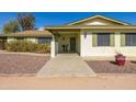 Inviting home entrance with a well-maintained walkway, potted plants, and a decorative front door at 22102 W Ripple Rd, Buckeye, AZ 85326