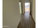 A view into the entry hallway featuring newly installed wood-look tile flooring and freshly painted, light neutral walls at 46940 W Coe St, Maricopa, AZ 85139