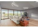 Contemporary living room with sleek furniture, hardwood floors, large windows, and modern lighting fixtures at 4808 N 24Th St # 906, Phoenix, AZ 85016