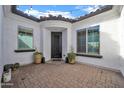 Inviting courtyard entrance with elegant door, tile flooring, and string lights above at 5172 S Seton Ave, Gilbert, AZ 85298