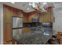 This kitchen is equipped with granite counters, stainless steel appliances, and wooden cabinets at 7147 E Rancho Vista Dr # 4007, Scottsdale, AZ 85251