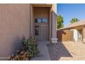 Inviting front entrance featuring neutral stucco, desert landscaping, and a decorative front door at 7830 S 26Th St, Phoenix, AZ 85042