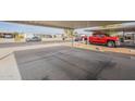 View of a carport and driveway area showcasing parking space and community street at 9709 E Empress Ave, Mesa, AZ 85208