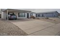Front view of a home with a paved driveway and covered parking with desert landscaping at 9709 E Empress Ave, Mesa, AZ 85208