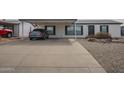 View of the home with a paved driveway and covered parking featuring attractive desert landscaping at 9709 E Empress Ave, Mesa, AZ 85208