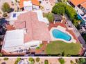Aerial view of a tile roof, sparkling pool, patio, lush yard, and manicured landscaping at 9740 E Gold Dust Ave, Scottsdale, AZ 85258